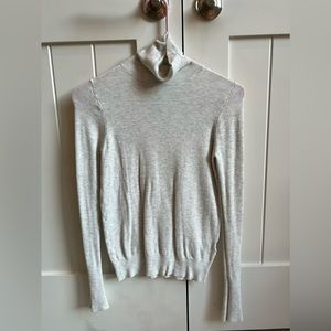 Light grey knit turtleneck with gold button detail on sleeve!